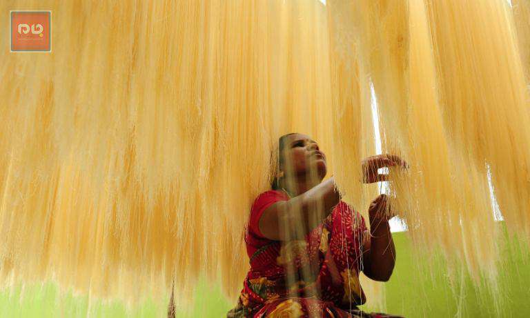یک زن هندی در حال خشک کردن رشته های نوعی شیرینی بمناسبت ماه مبارک رمضان